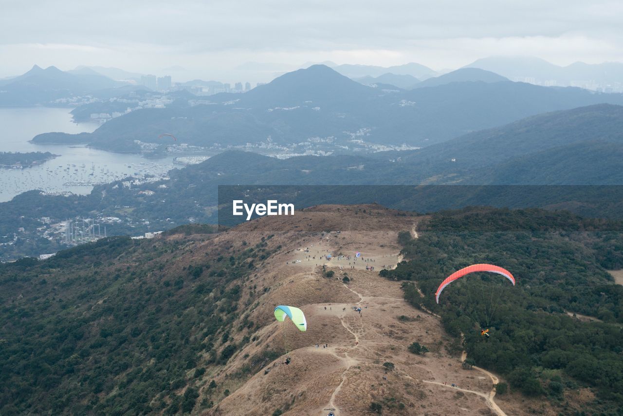 High angle view of people paragliding against mountains