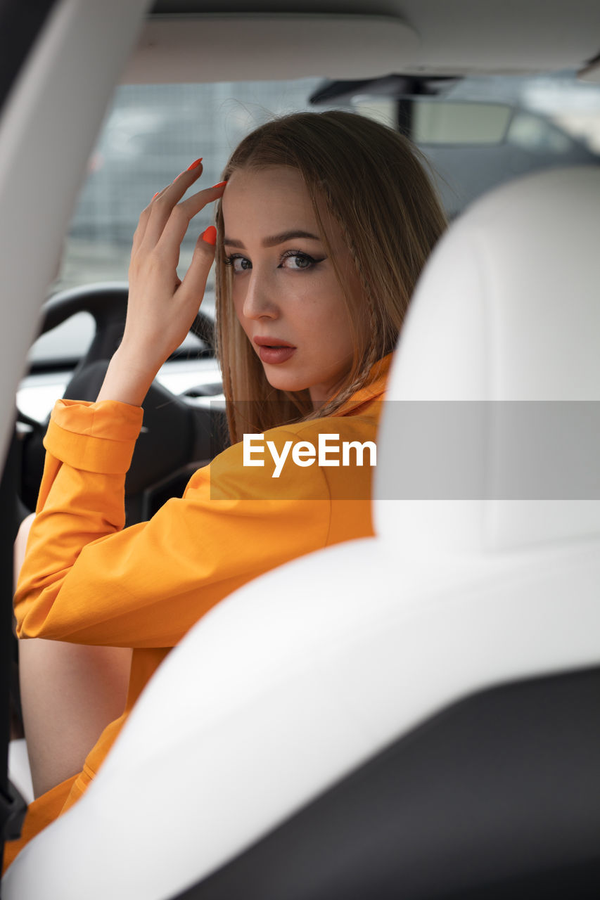 Side view of woman using mobile phone while sitting in car