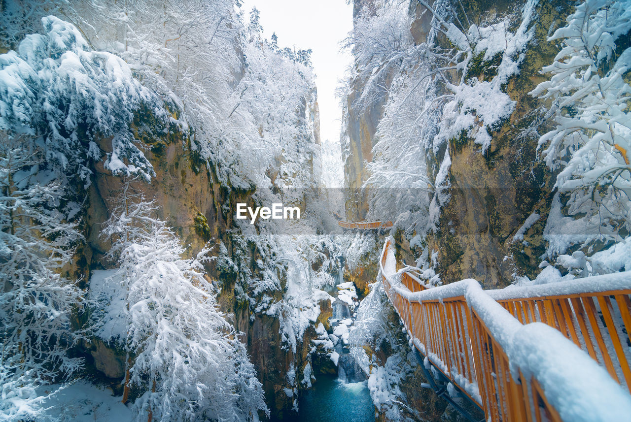View of footbridge over snow covered land during winter
