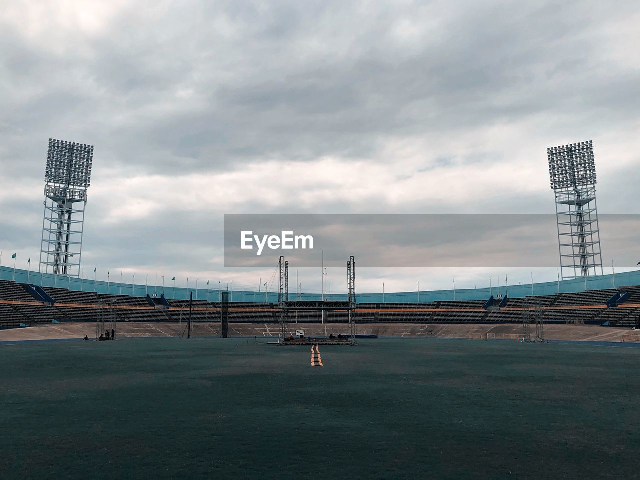 Stadium against cloudy sky in city