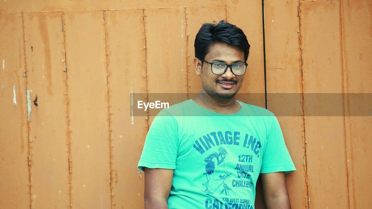 Portrait of smiling man against wall