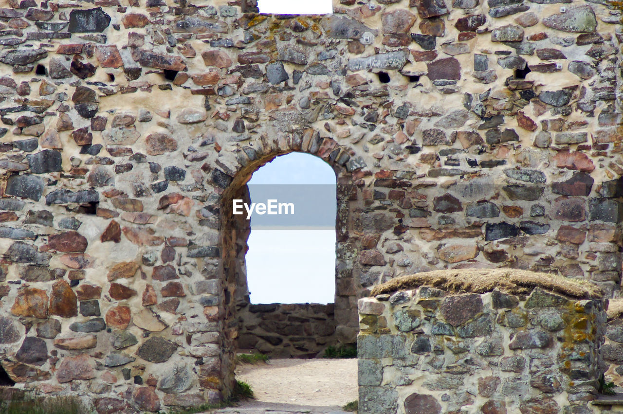 STONE WALL WITH OLD BUILDING