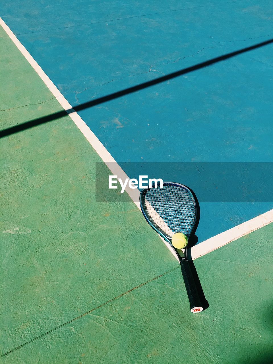 High angle view of tennis ball and racket on court
