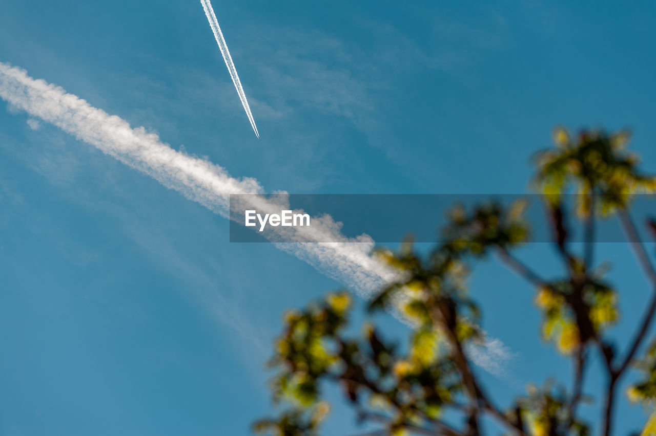 LOW ANGLE VIEW OF VAPOR TRAILS AGAINST SKY