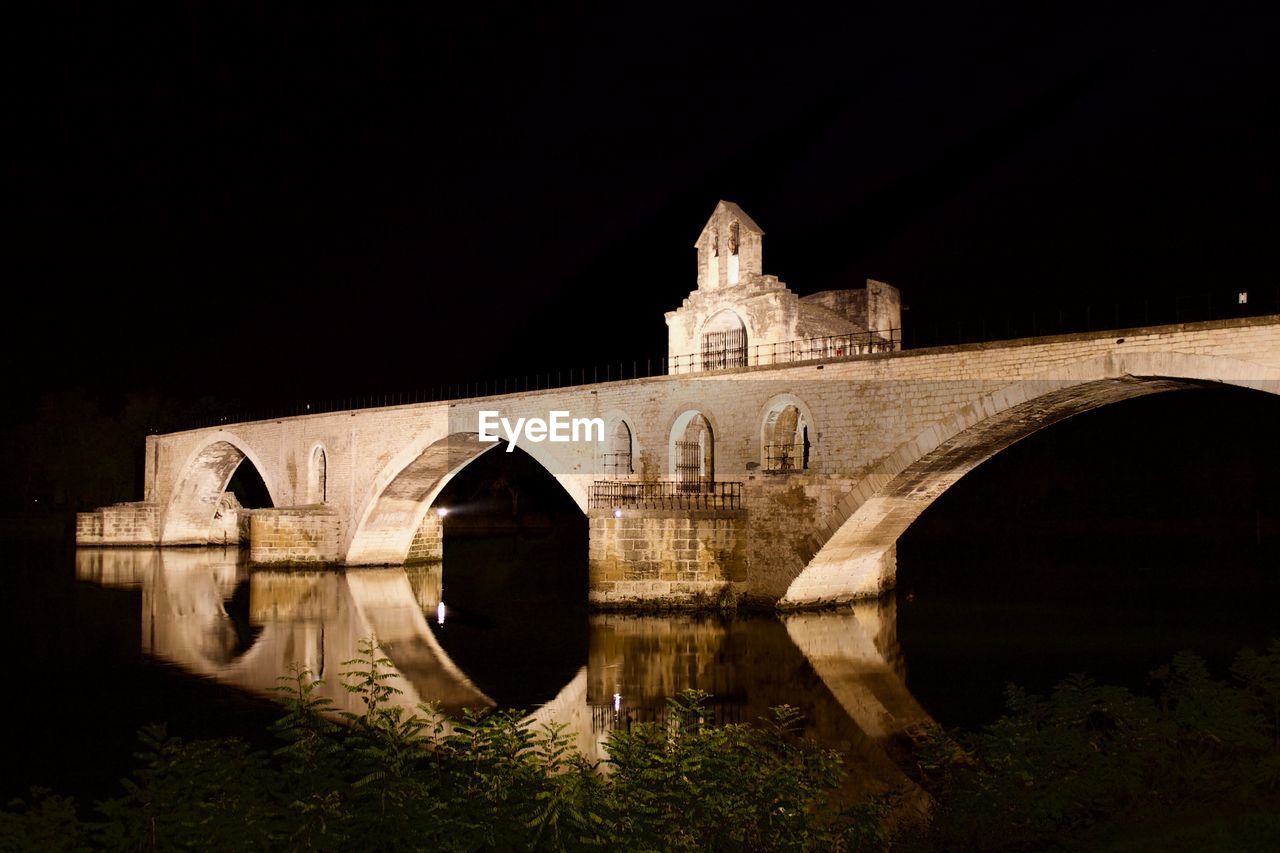 Arch bridge against clear sky at night