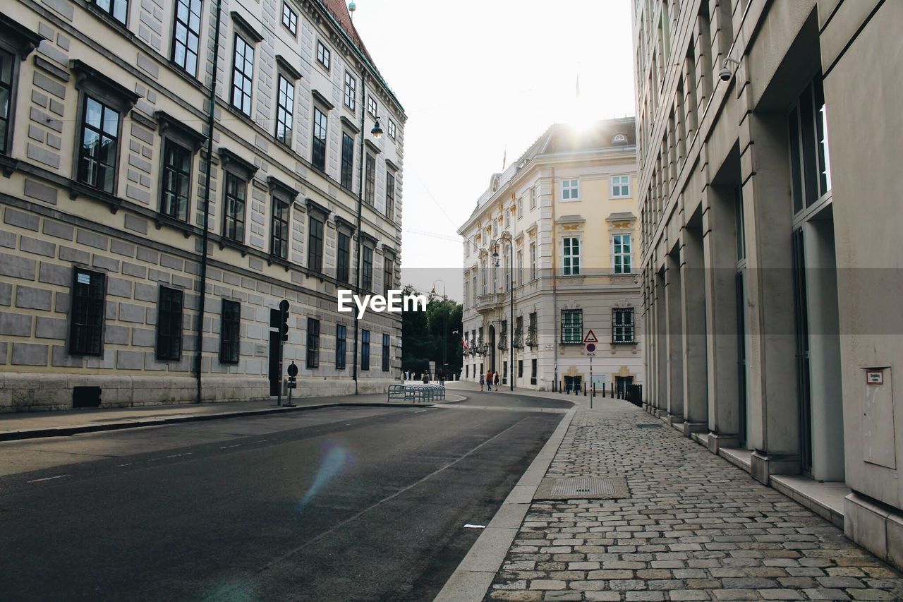 STREET AMIDST BUILDINGS AGAINST SKY