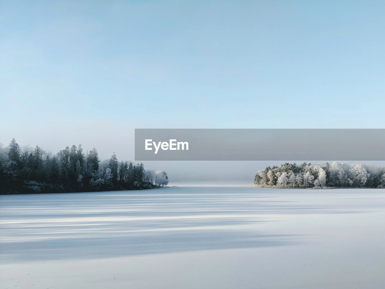 Scenic view of lake against clear sky during winter