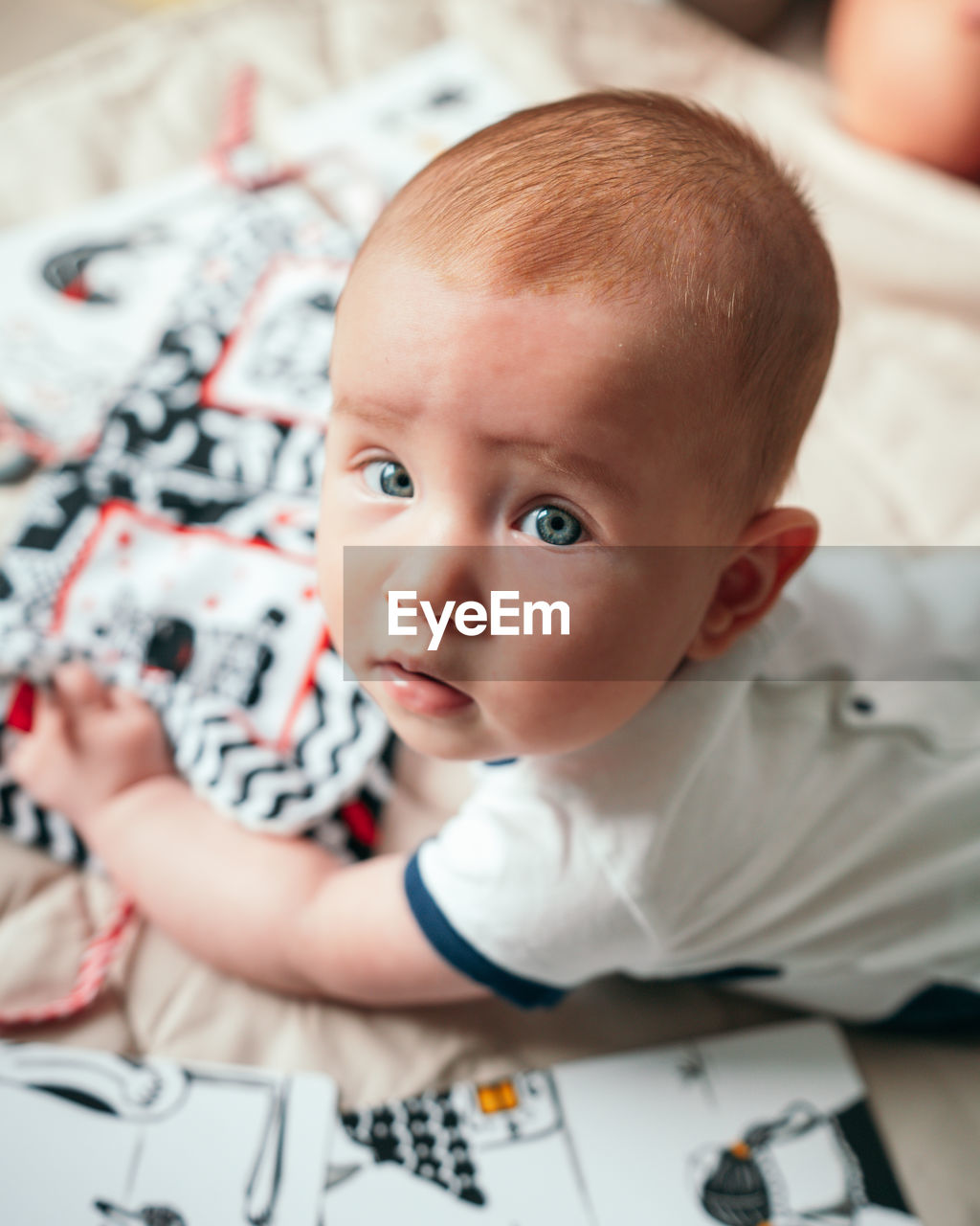 Portrait of cute baby boy on bed at home