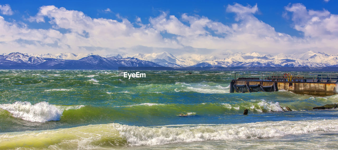 Huge waves crashing over the avacha bay on the stone pier on kamchatka.