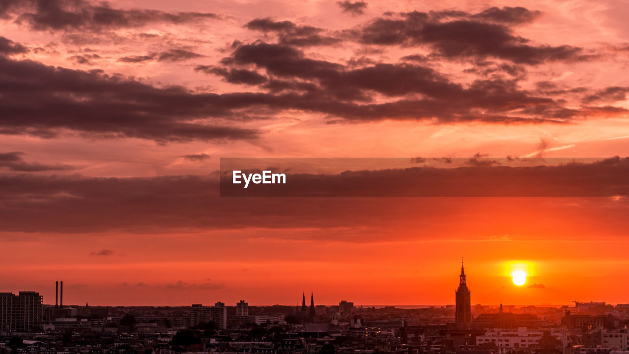 View of buildings against cloudy sky during sunset