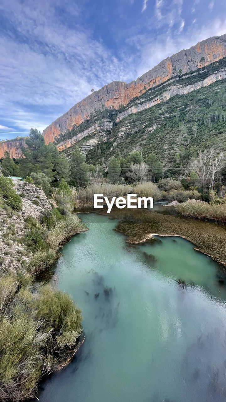 high angle view of river amidst mountains against sky