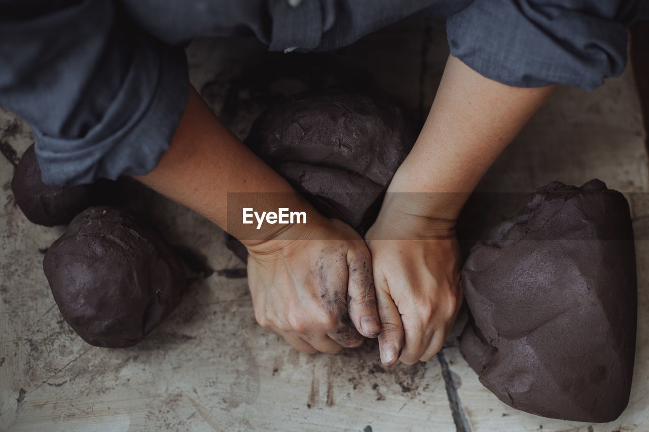 Middle-aged woman working in a pottery studio with clay