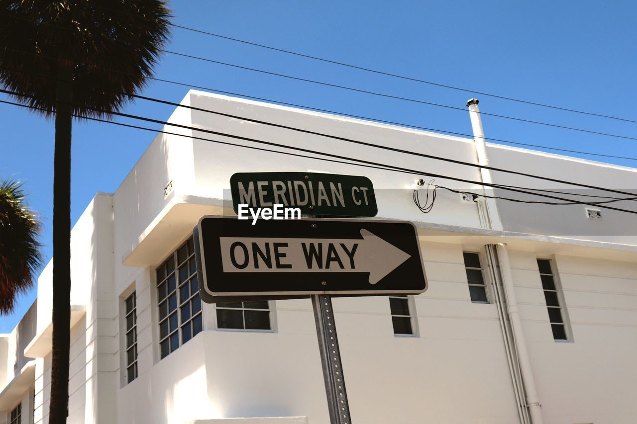 LOW ANGLE VIEW OF ROAD SIGNS AGAINST BUILDING