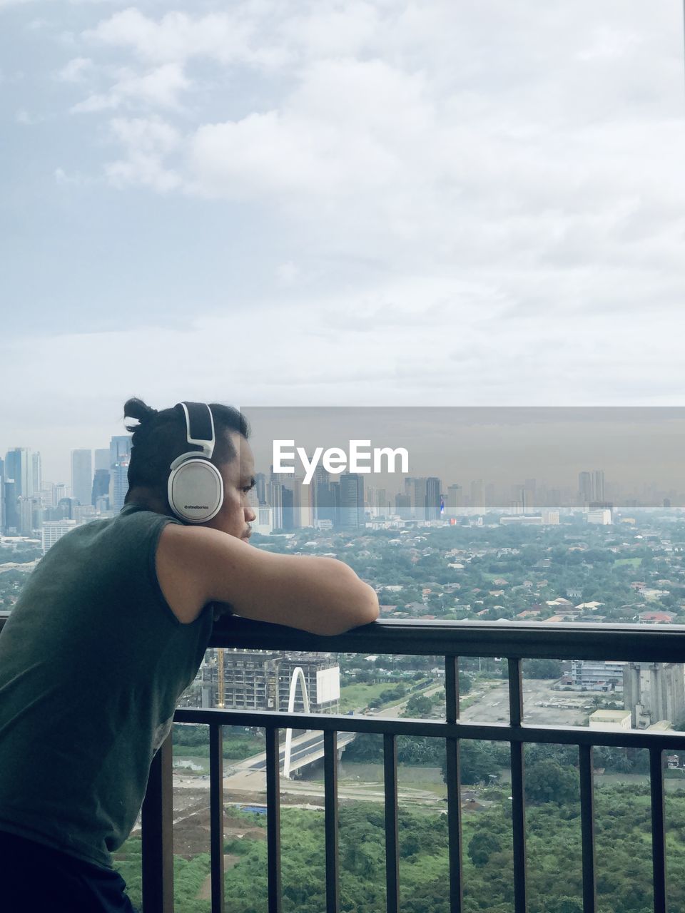 Side view of man against city skyline from a balcony