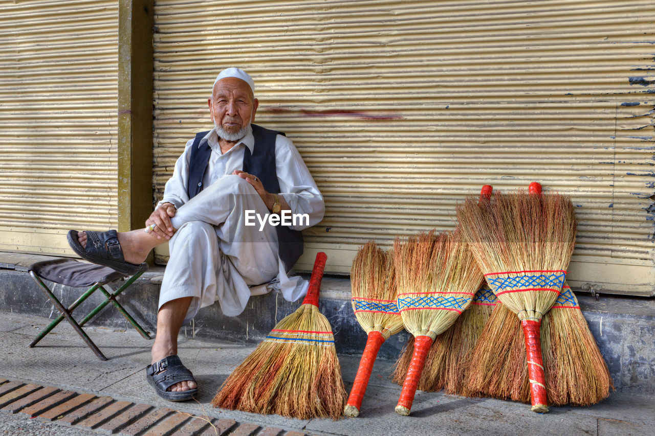 PORTRAIT OF A SMILING MAN SITTING ON SEAT