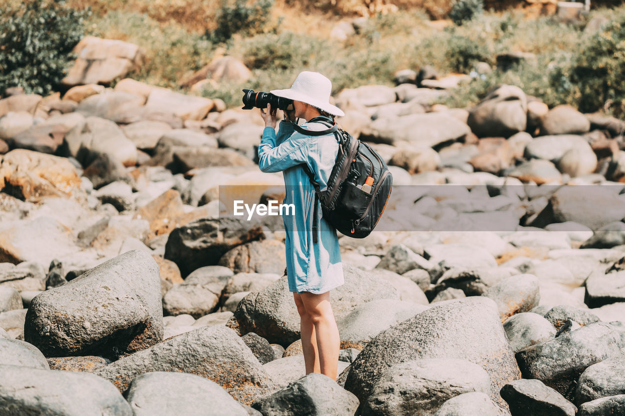 Rear view of woman standing on rock