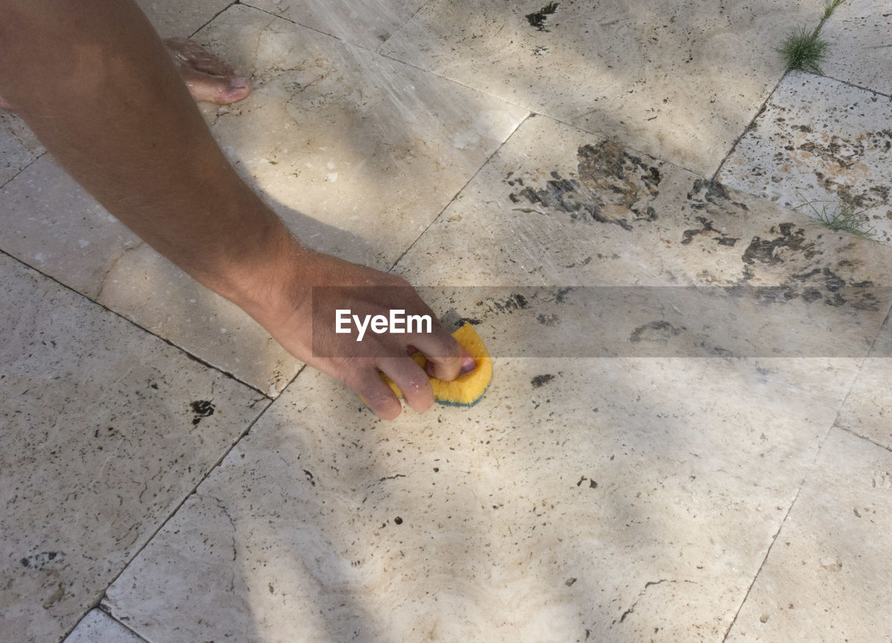 floor, flooring, one person, high angle view, hand, sand, soil, day, lifestyles, road surface, nature, outdoors, land, low section, human leg, leisure activity, human limb, beach, men