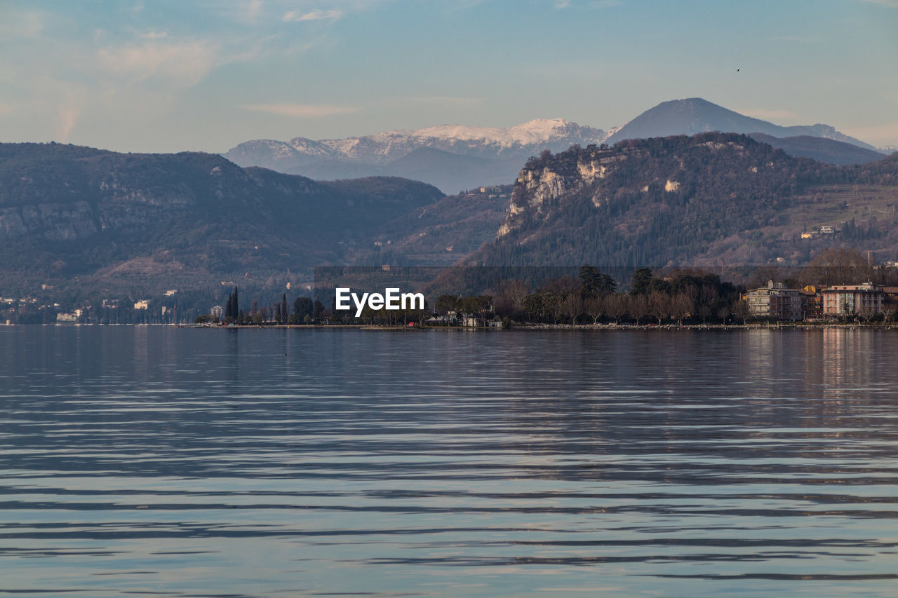 Scenic view of lake by mountains against sky