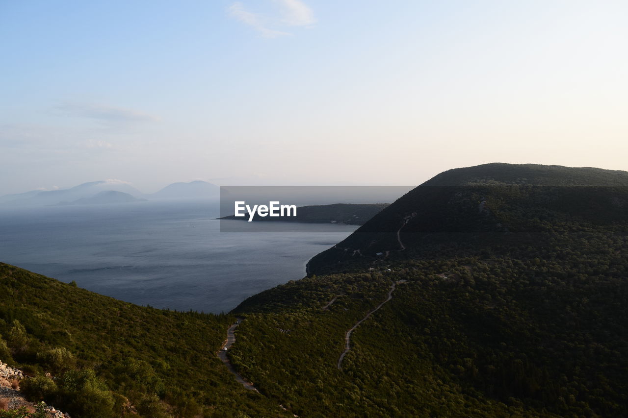 Scenic view of sea and mountains against sky