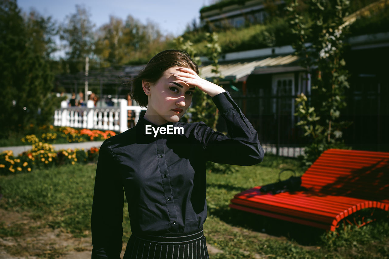 Woman standing at lawn during sunny day