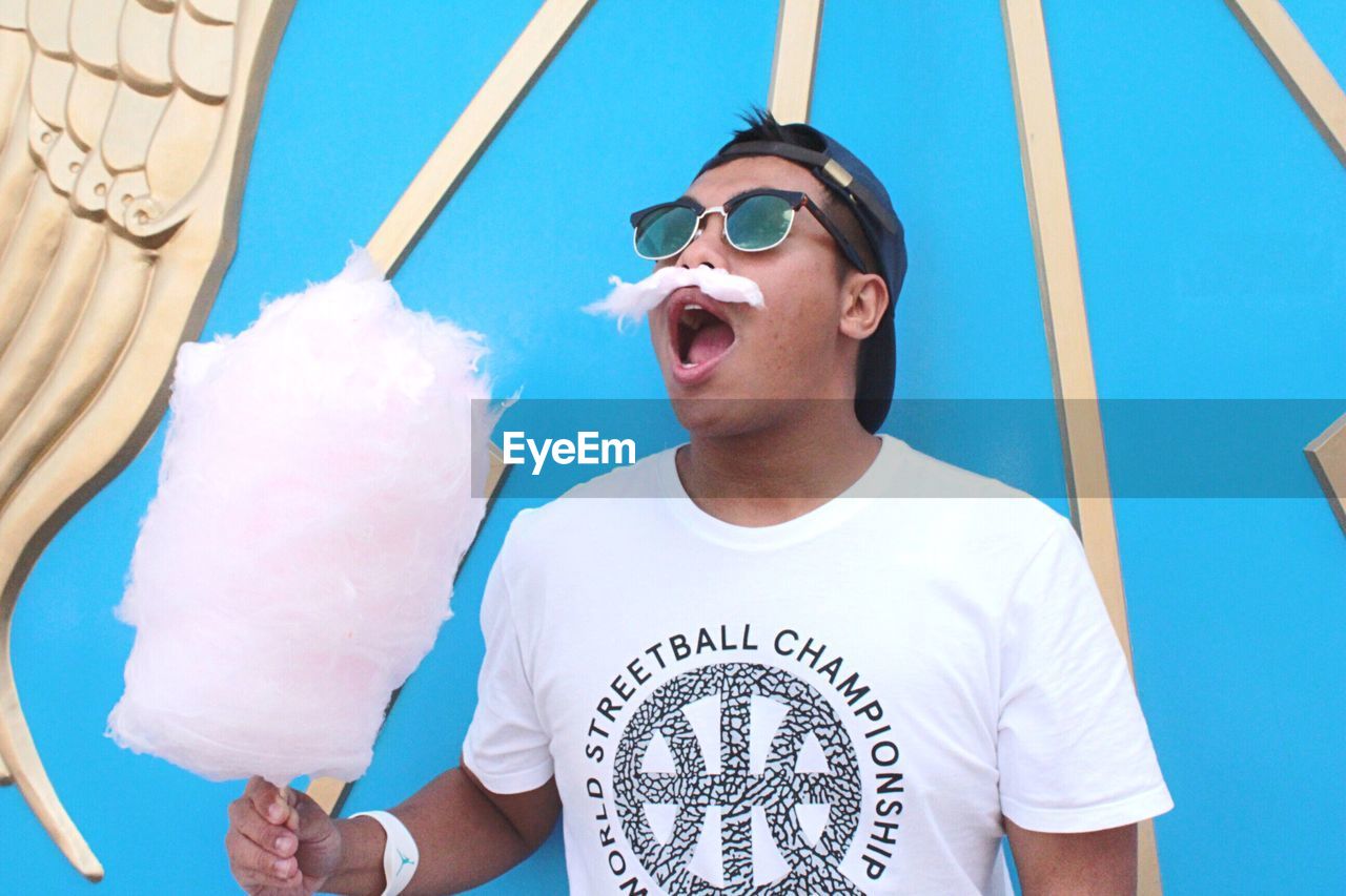 Man holding cotton candy at park