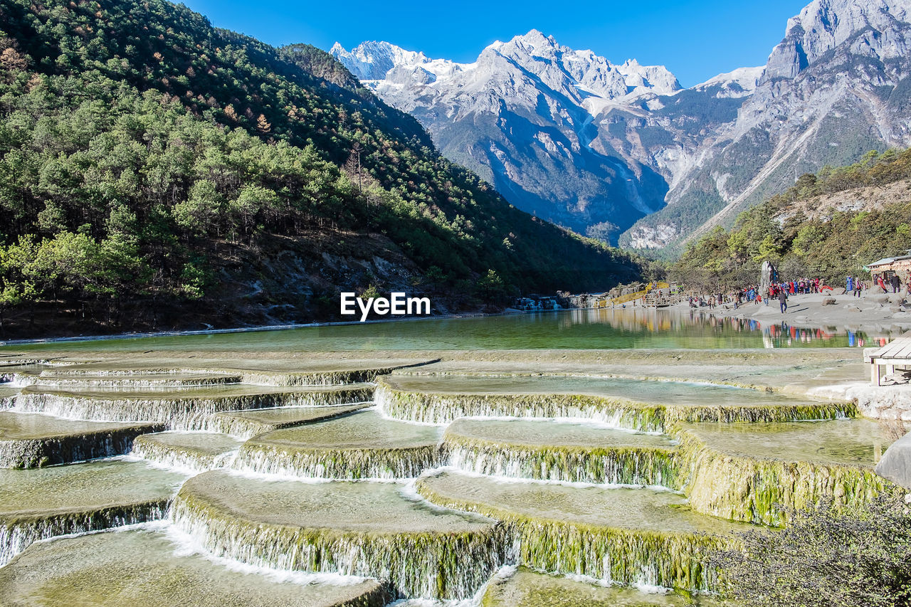 SCENIC VIEW OF MOUNTAINS AND TREES AGAINST SKY