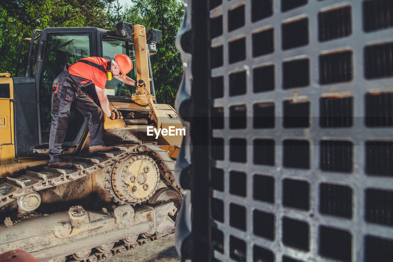 Construction worker repairing bulldozer