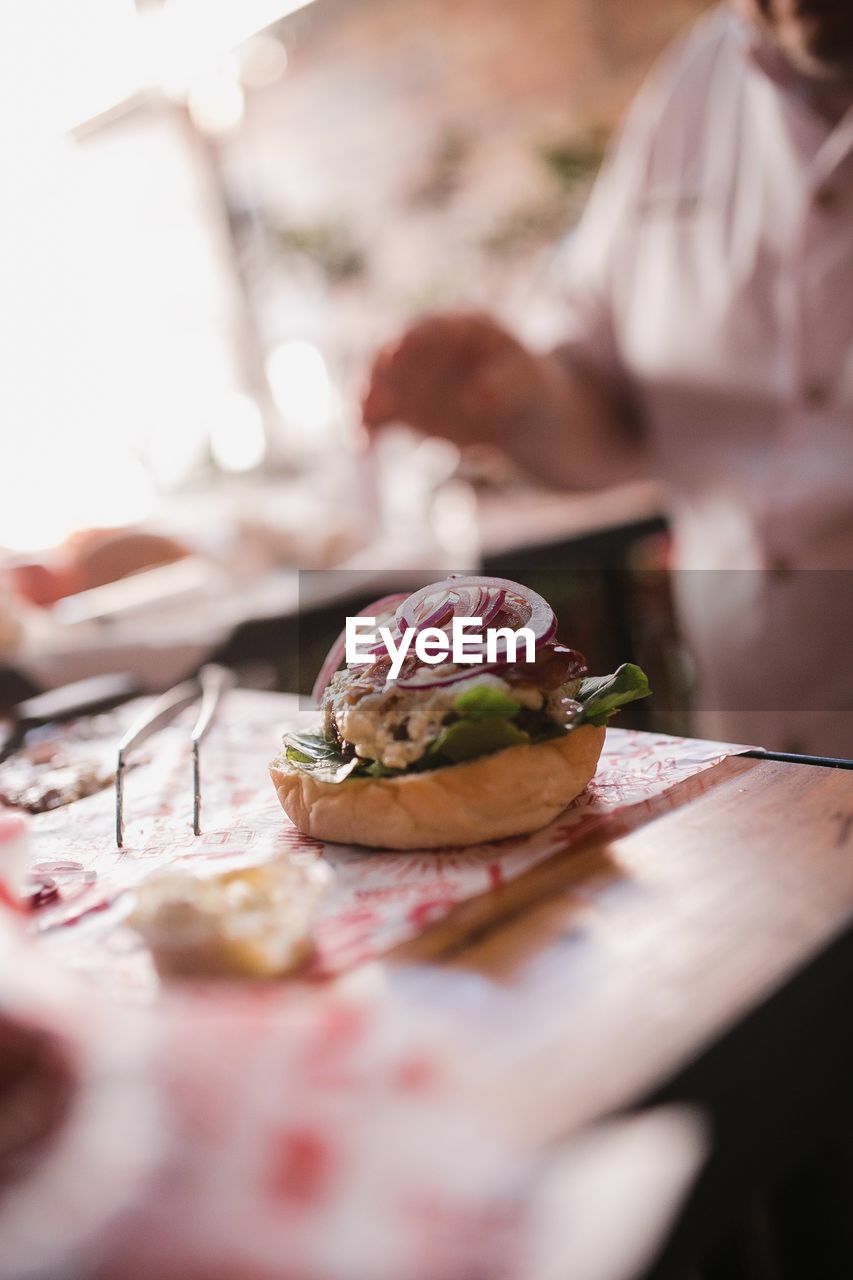 Close-up of hand preparing a burger