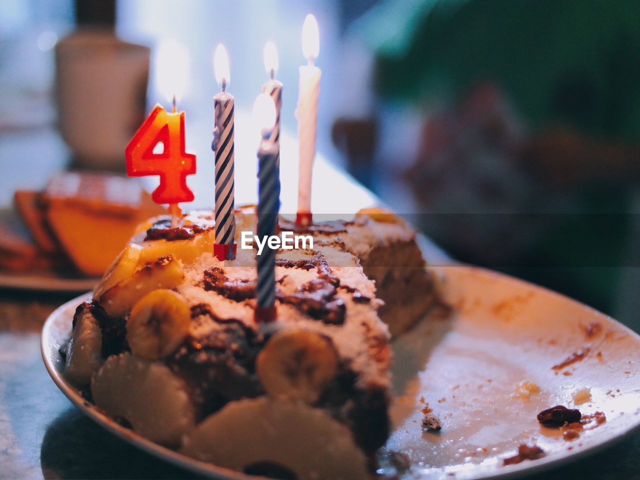 Close-up of birthday cake with candles in plate on table