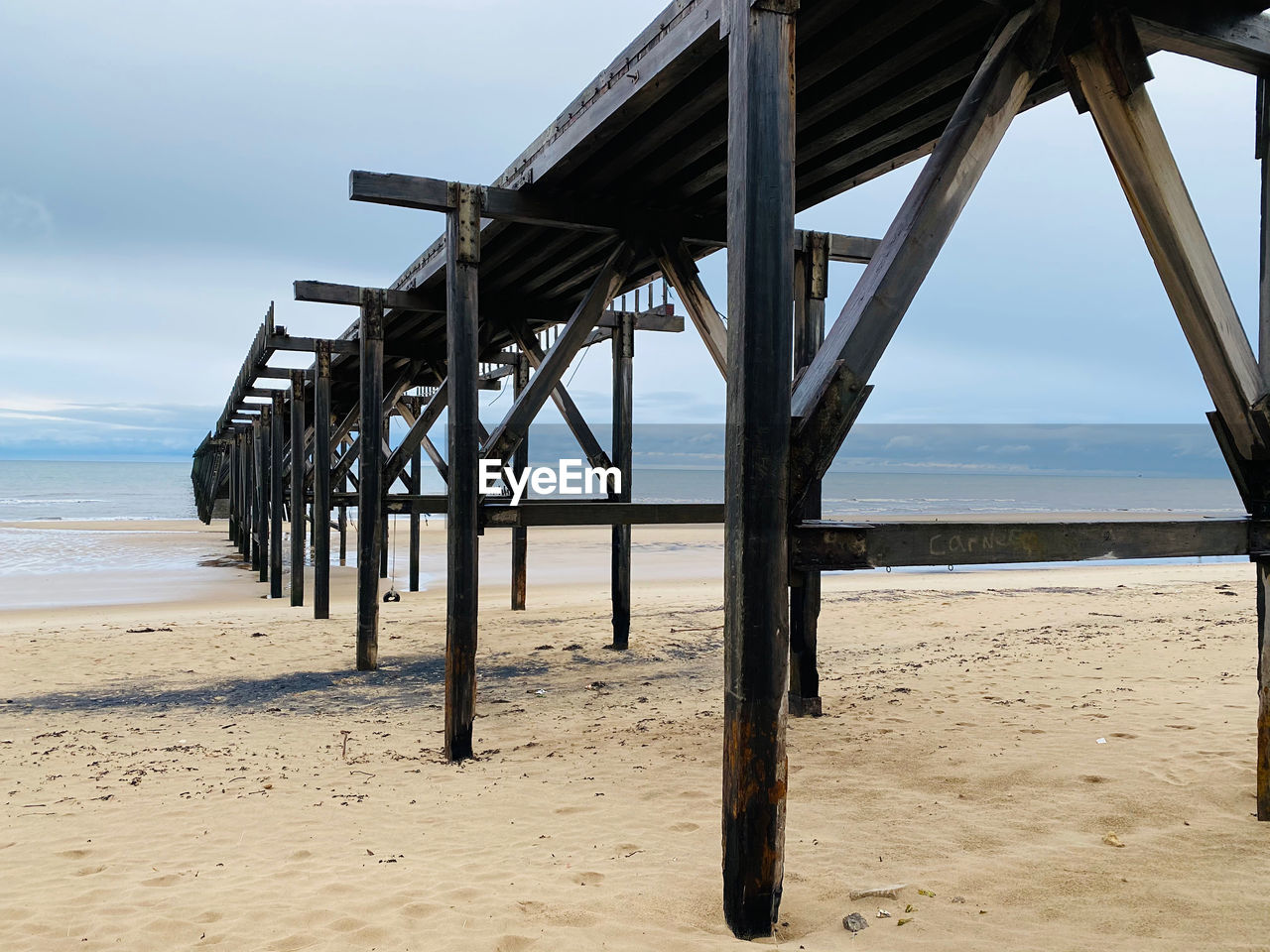 View of pier on beach against sky