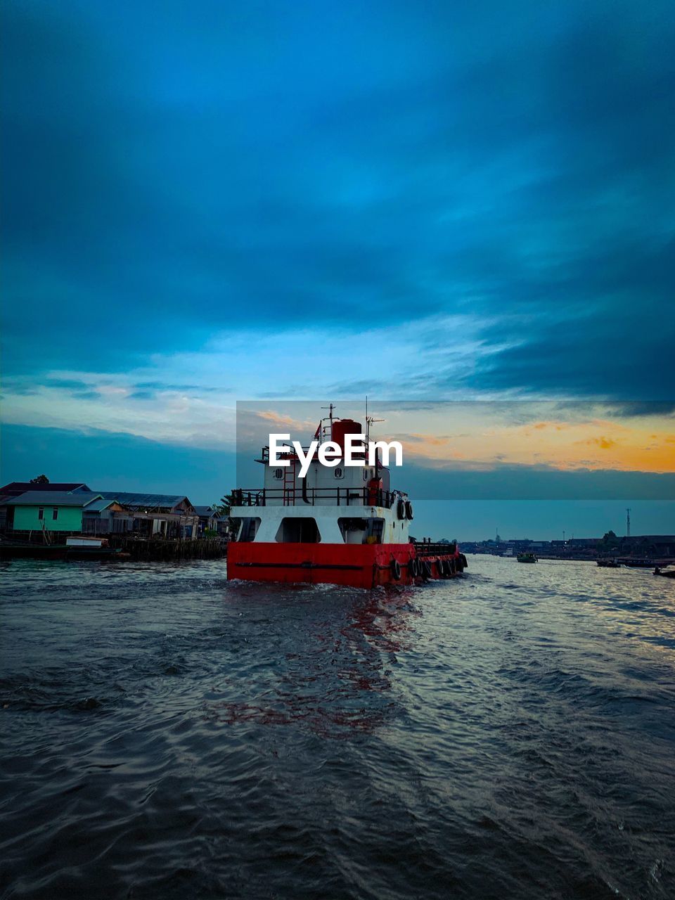 Fishing boat in sea against sky at sunset