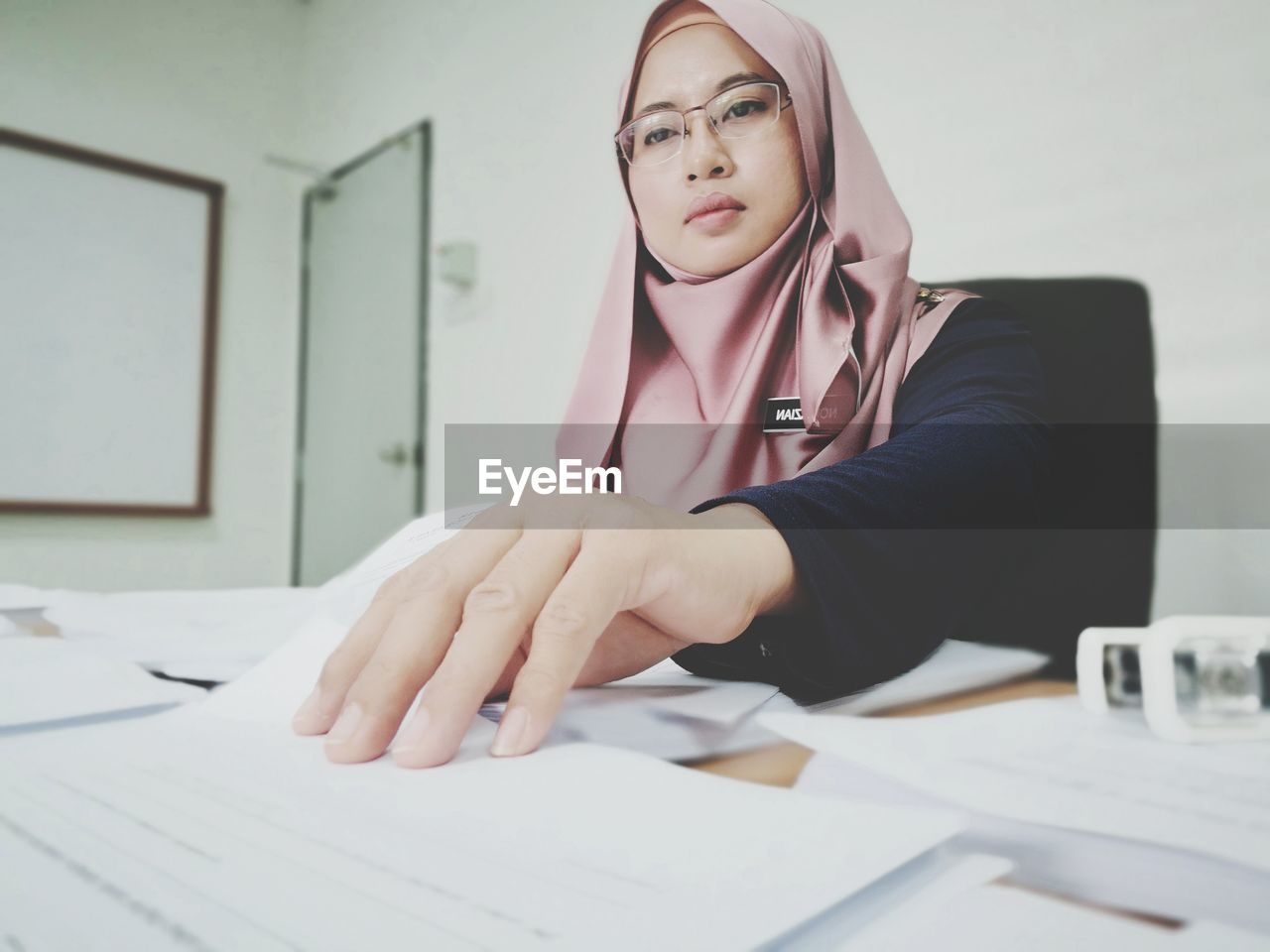 Businesswoman in hijab doing paperwork at office