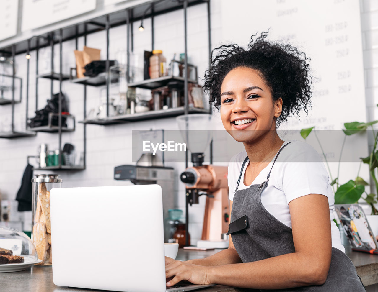 portrait of young woman using mobile phone in factory