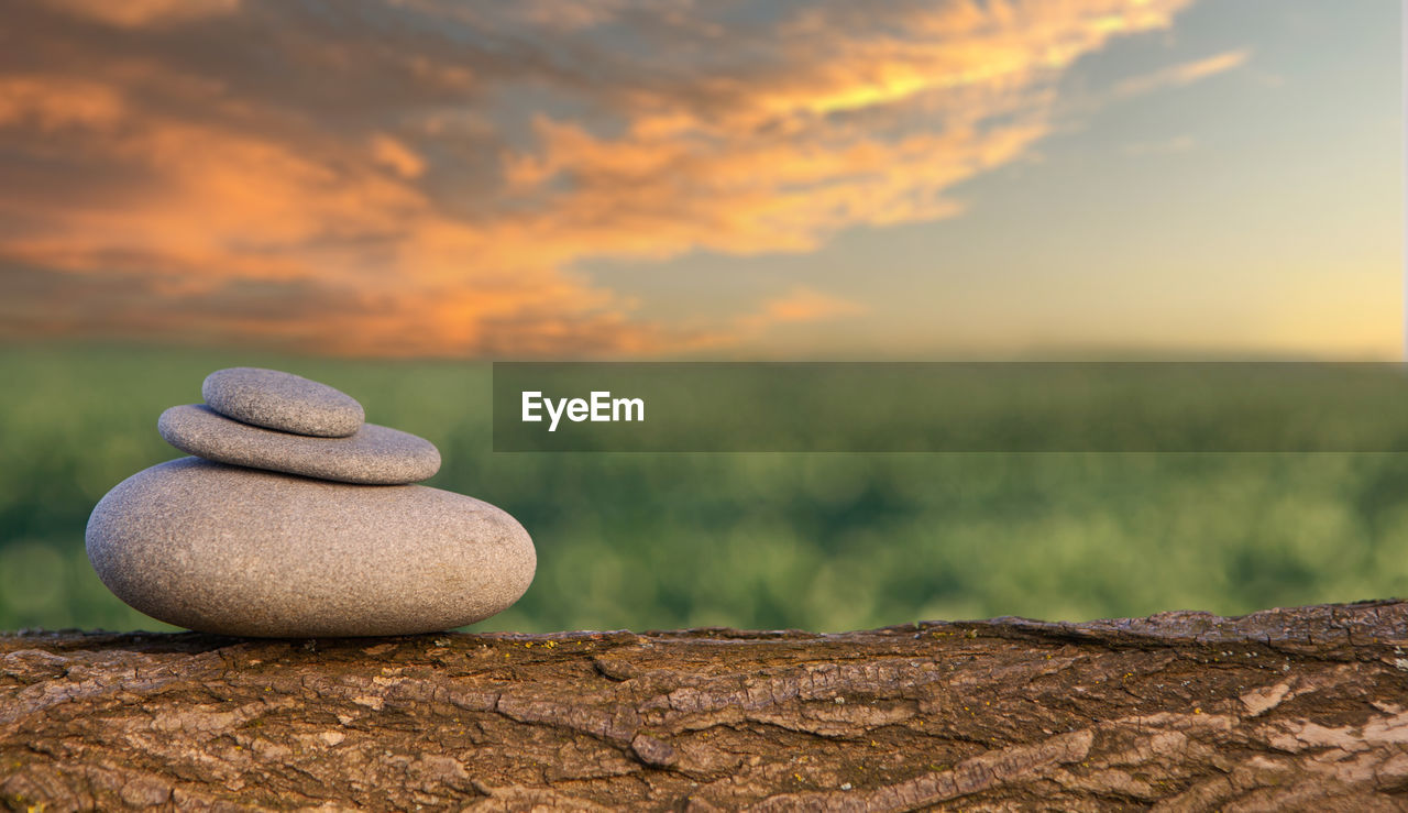 CLOSE-UP OF STONES ON ROCK AGAINST SKY