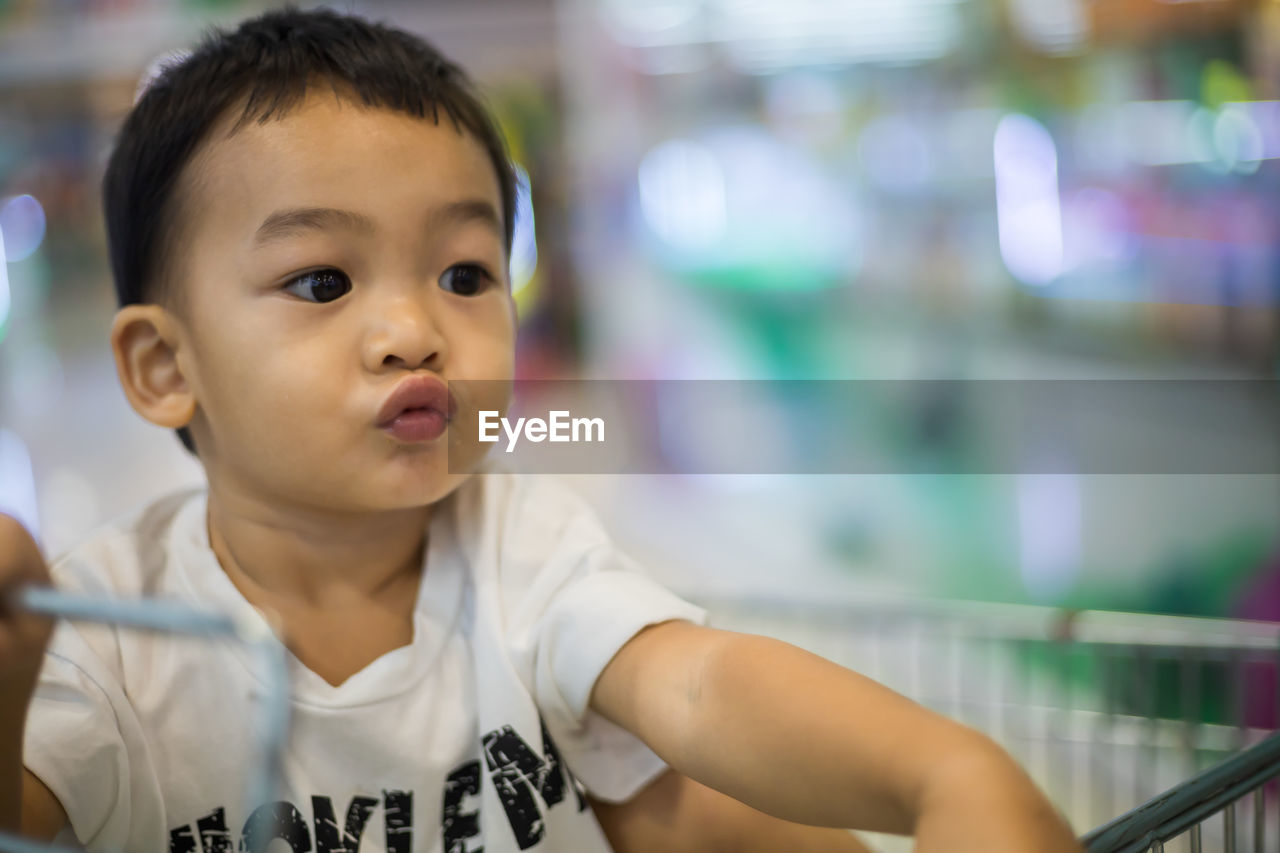 Close-up of cute boy puckering in store