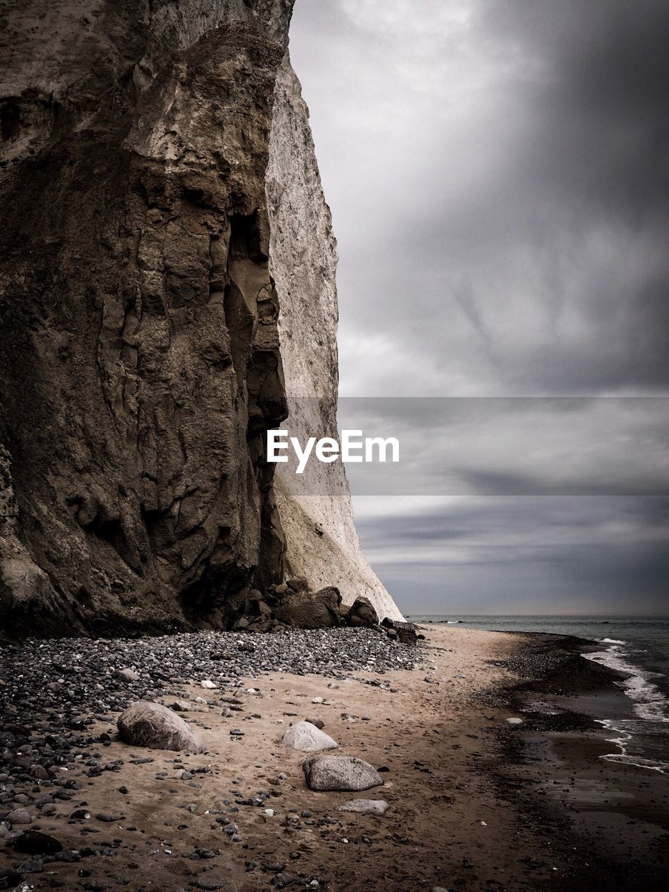 Rock formation at beach against sky