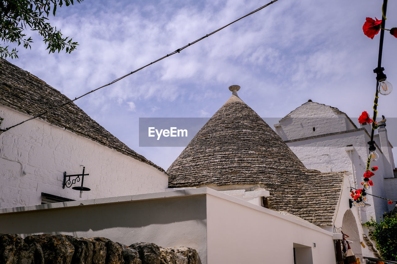 Low angle view of trulli buildings against sky