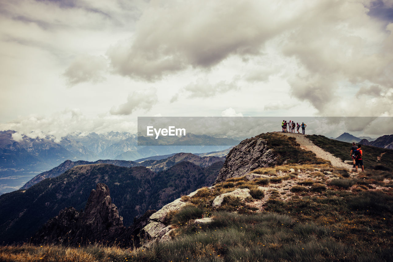 People on mountain against sky