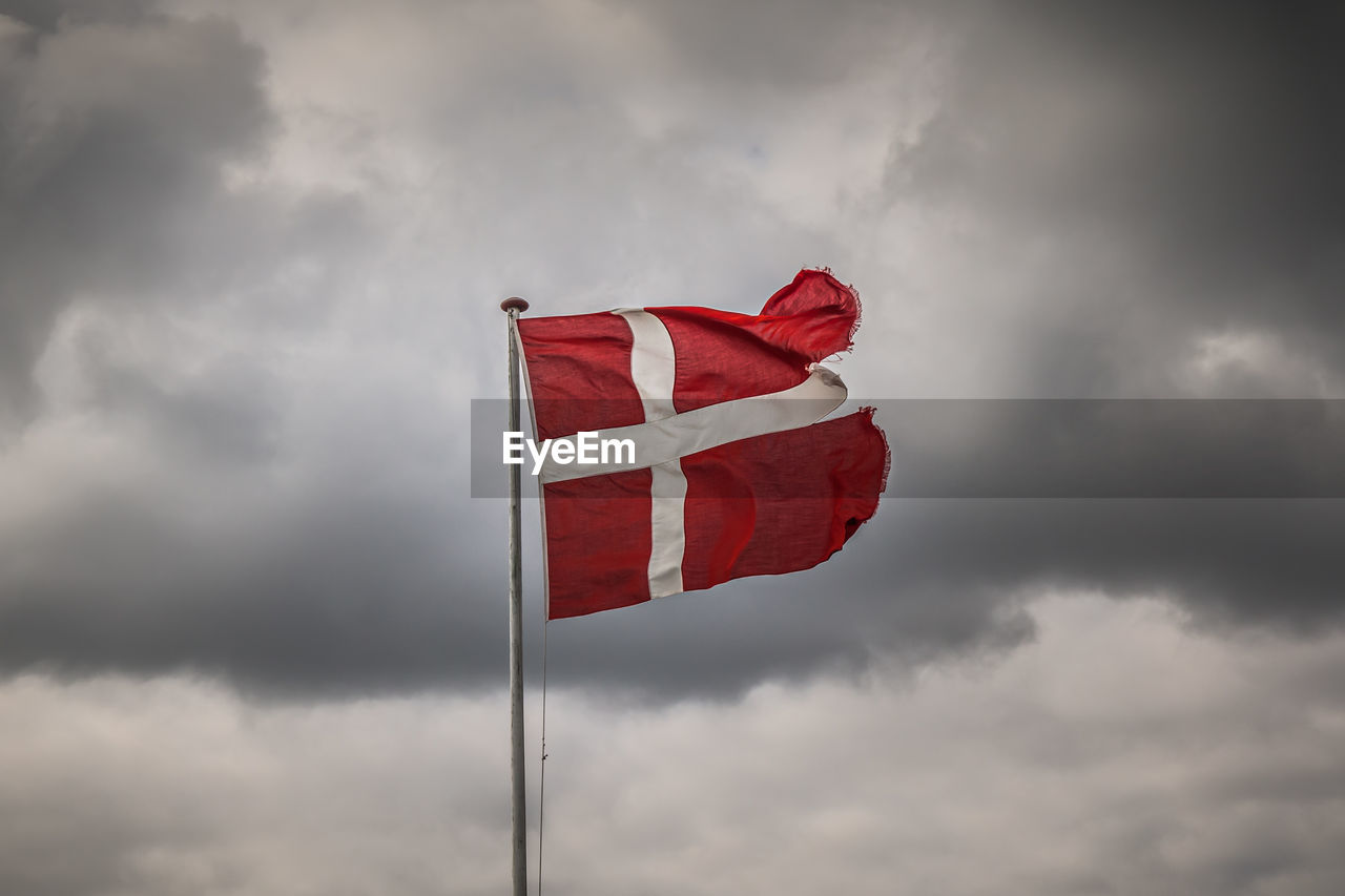 LOW ANGLE VIEW OF FLAGS AGAINST CLOUDY SKY