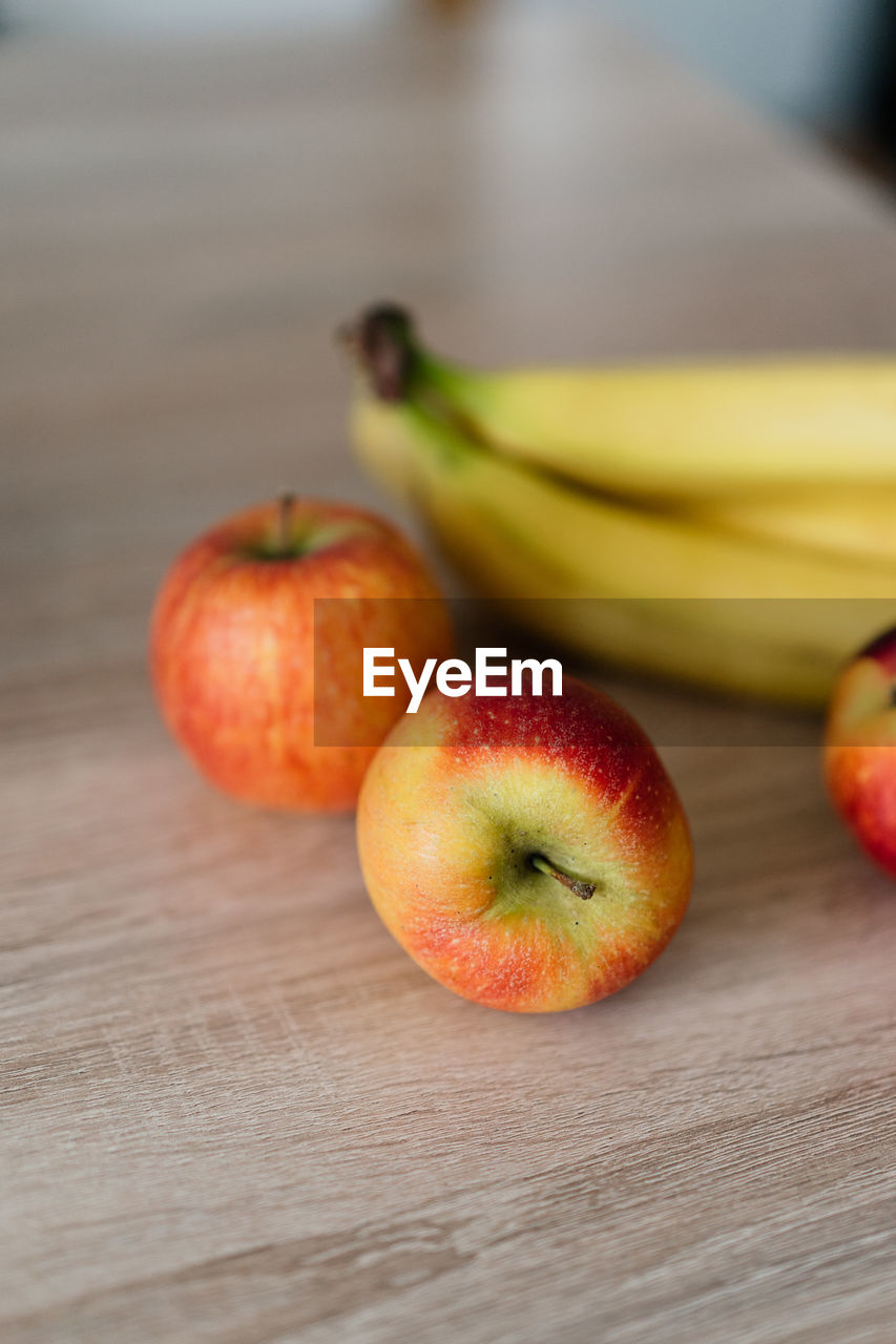 Close-up of apples and bananas on table