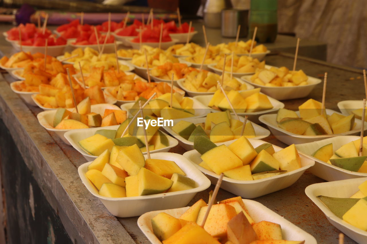 Fruits in bowls at market for sale