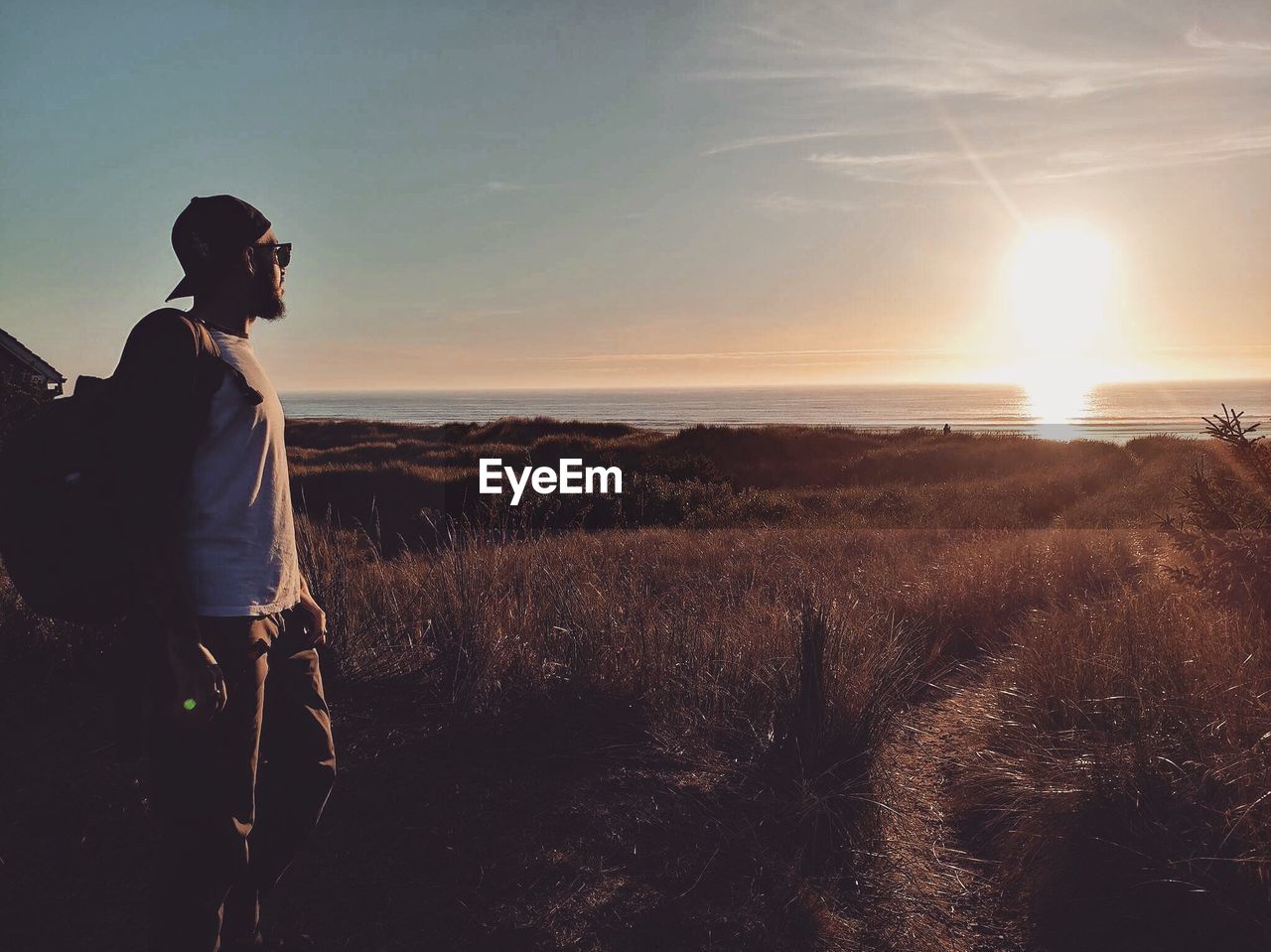 Man on field against sky during sunset