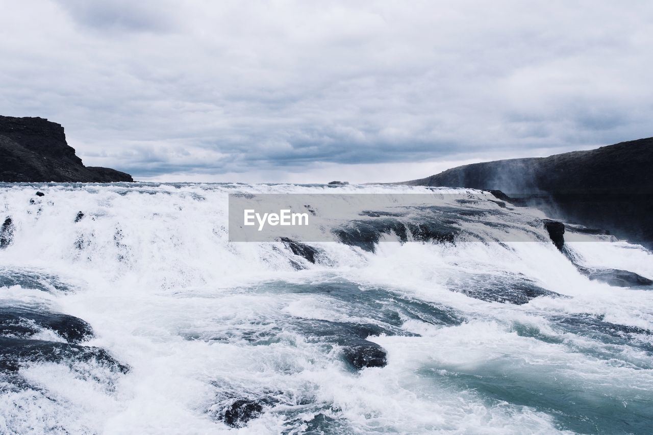 SCENIC VIEW OF WAVES BREAKING AGAINST SKY