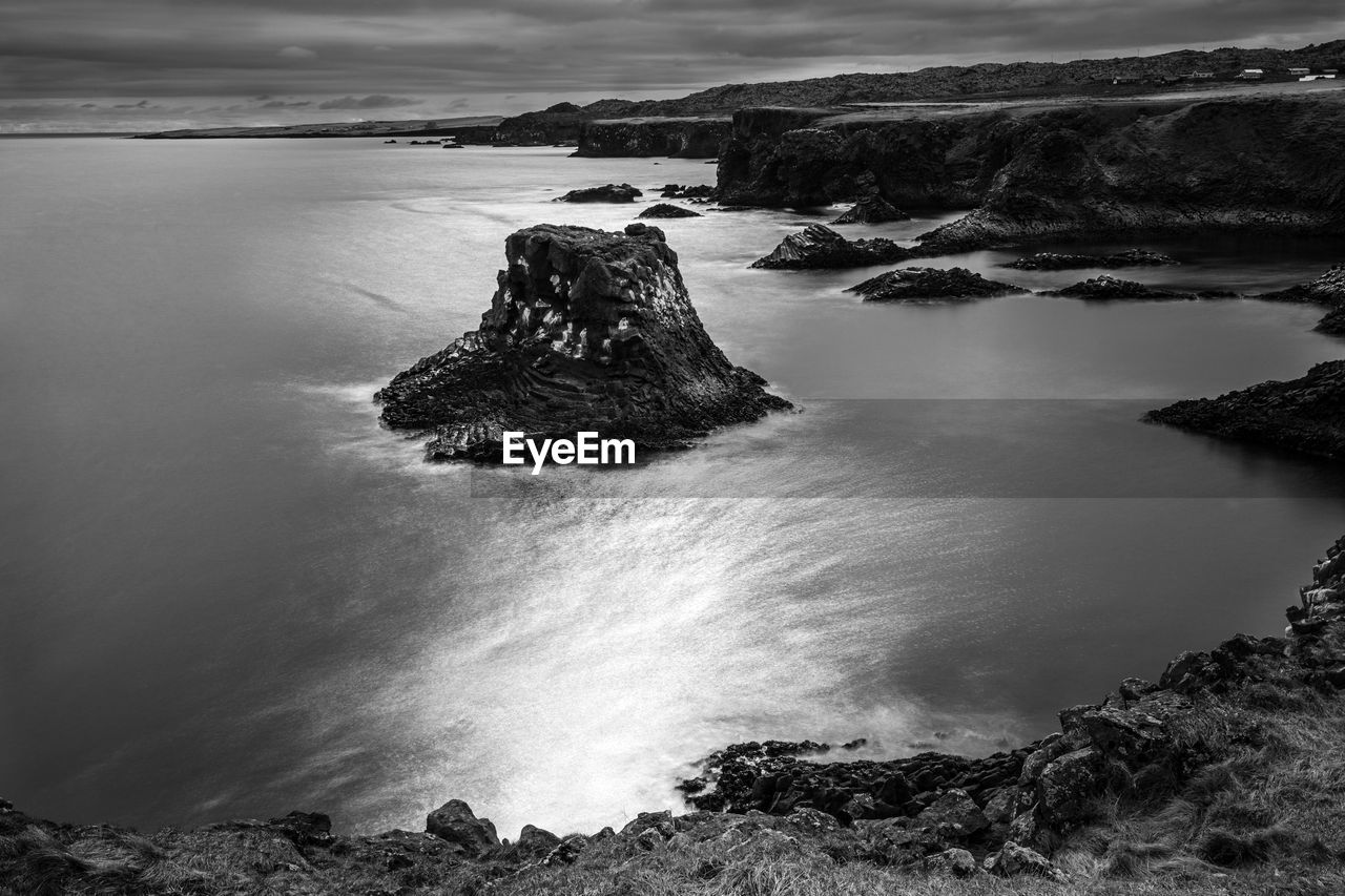 Rock formation in sea against sky