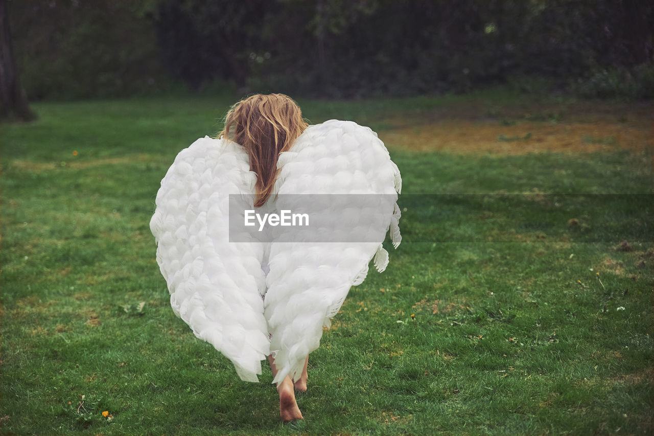 rear view of woman standing on grass