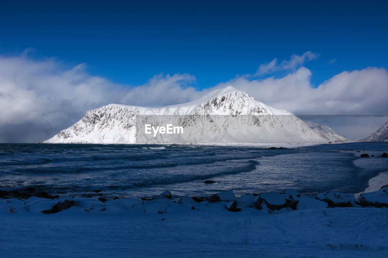 Scenic view of sea and snowcapped mountains against sky norway