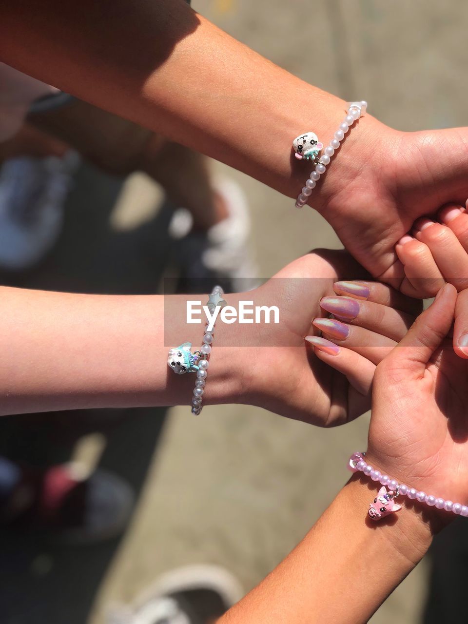 Cropped hands of women showing bracelets