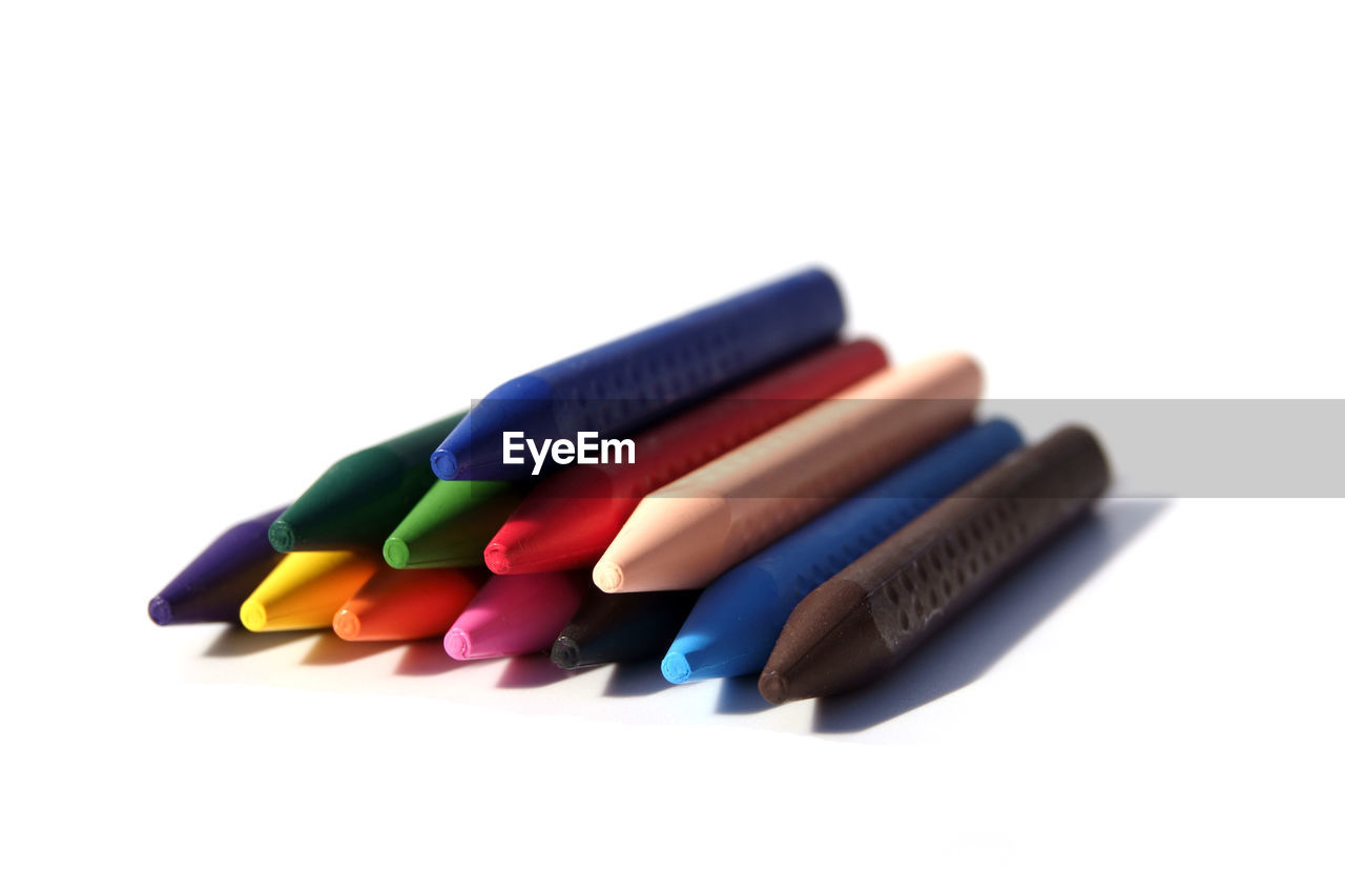 Close-up of crayons over white background