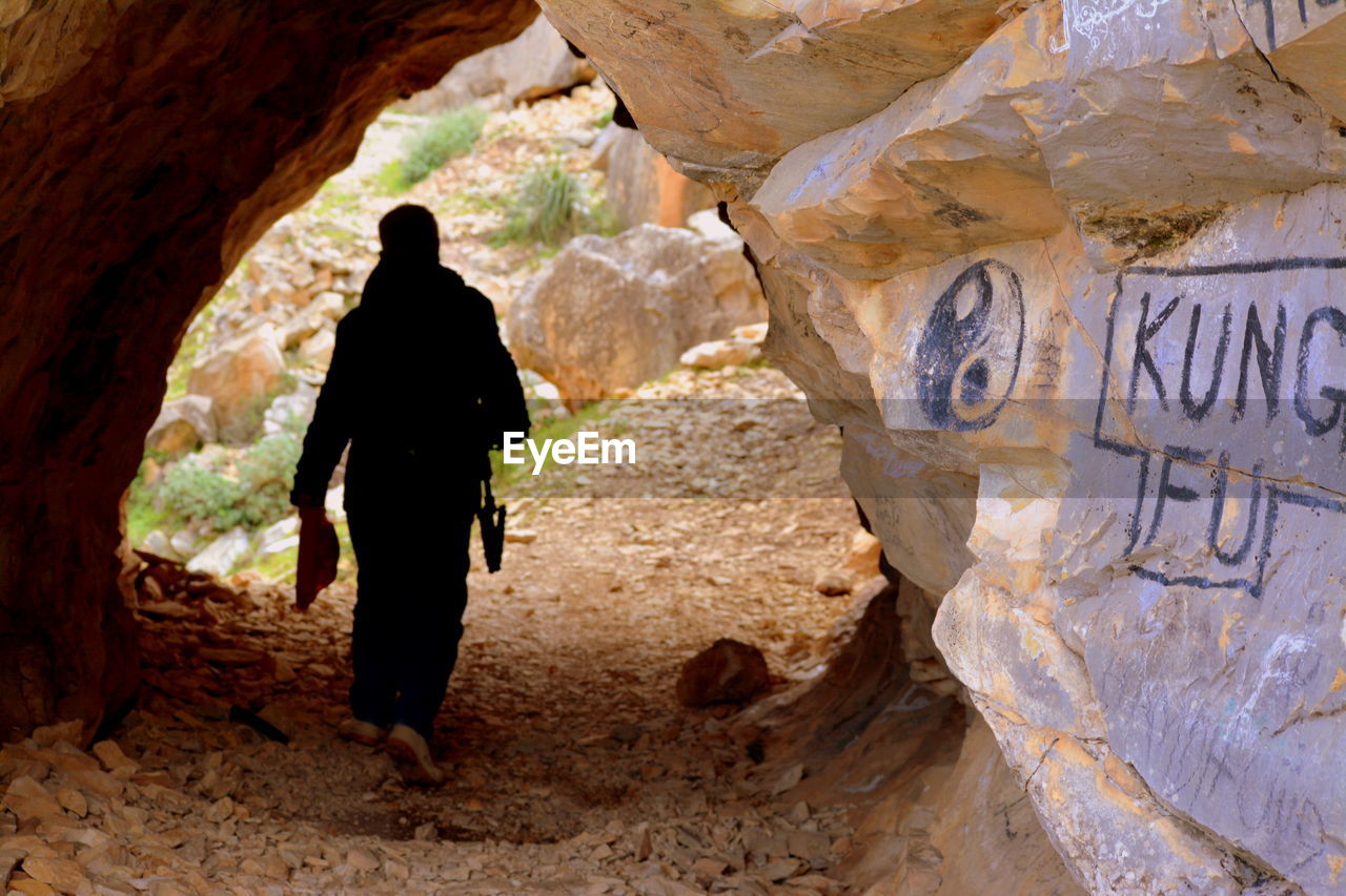 Rear view of man standing on rock