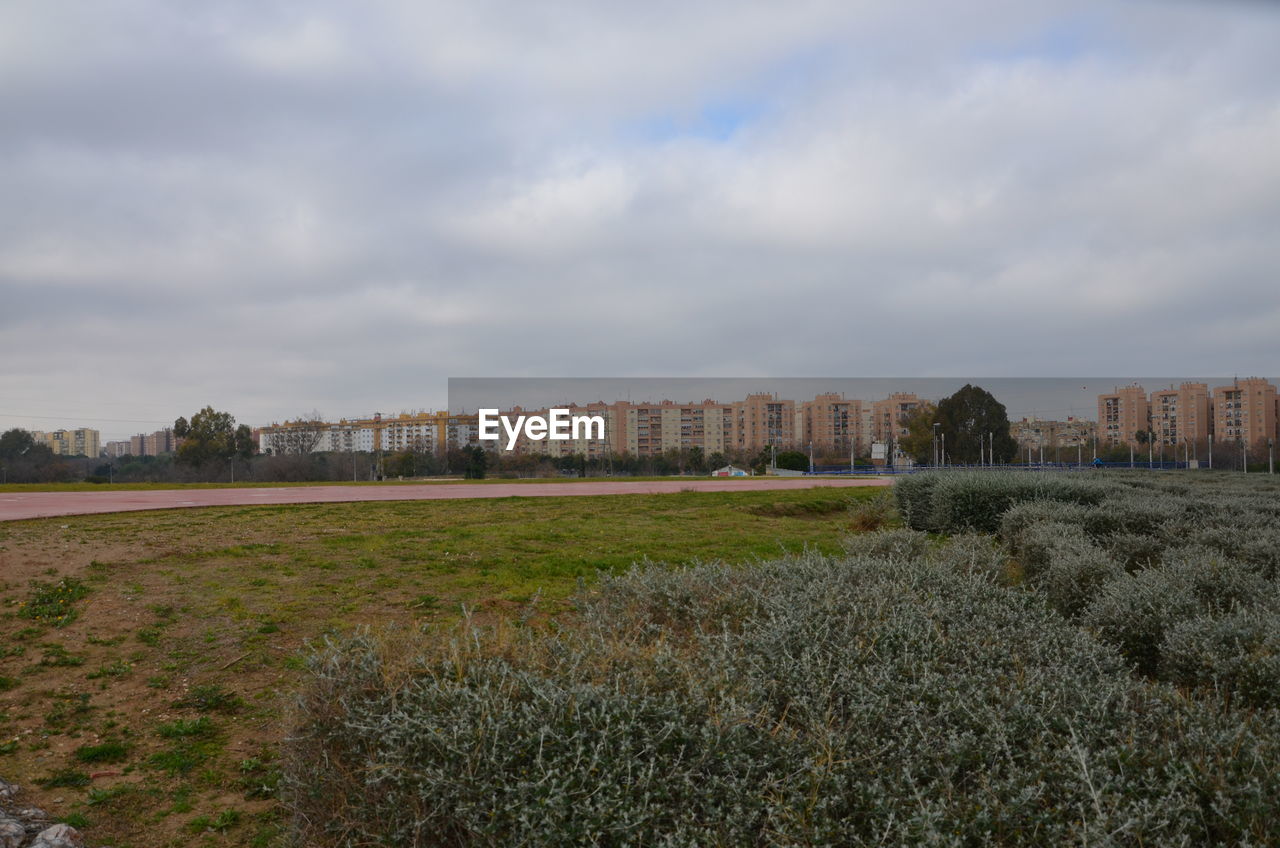 VIEW OF BUILDINGS AGAINST CLOUDY SKY